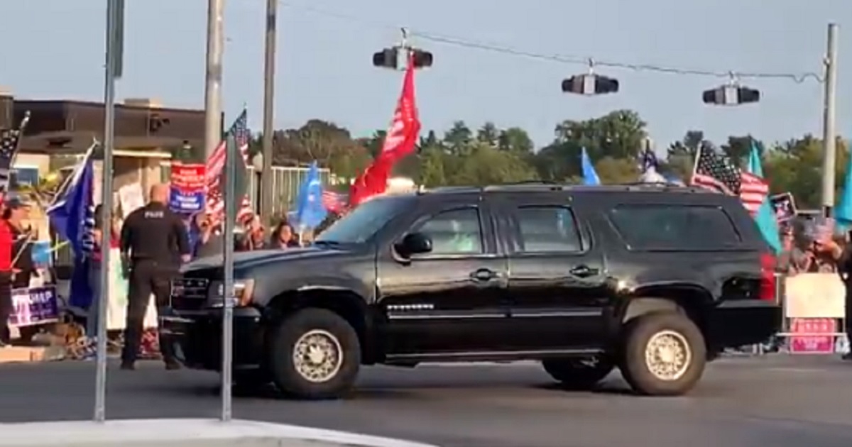 A vehicle carrying President Donald Trump does a drive-by of Trump supporters rallied outside Walter Reed National Military Medical Center on Sunday.