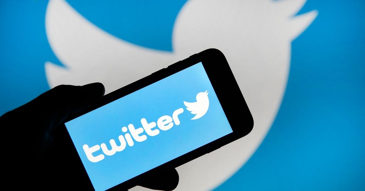 In this photo illustration, the Twitter logo is displayed on the screen of an iPhone in front of a computer screen displaying a Twitter logo on Feb. 7, 2019, in Paris.