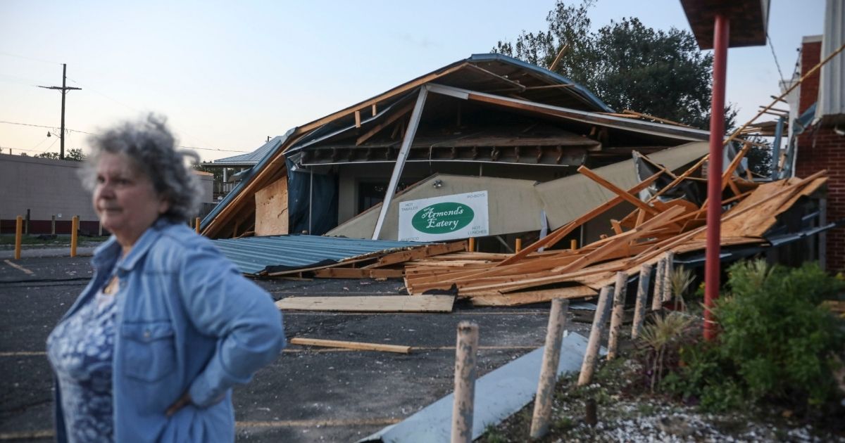 A woman stands in front of a destroyed restaurant after Hurricane Zeta on Oct. 29, 2020, in Chalmette, Louisiana.