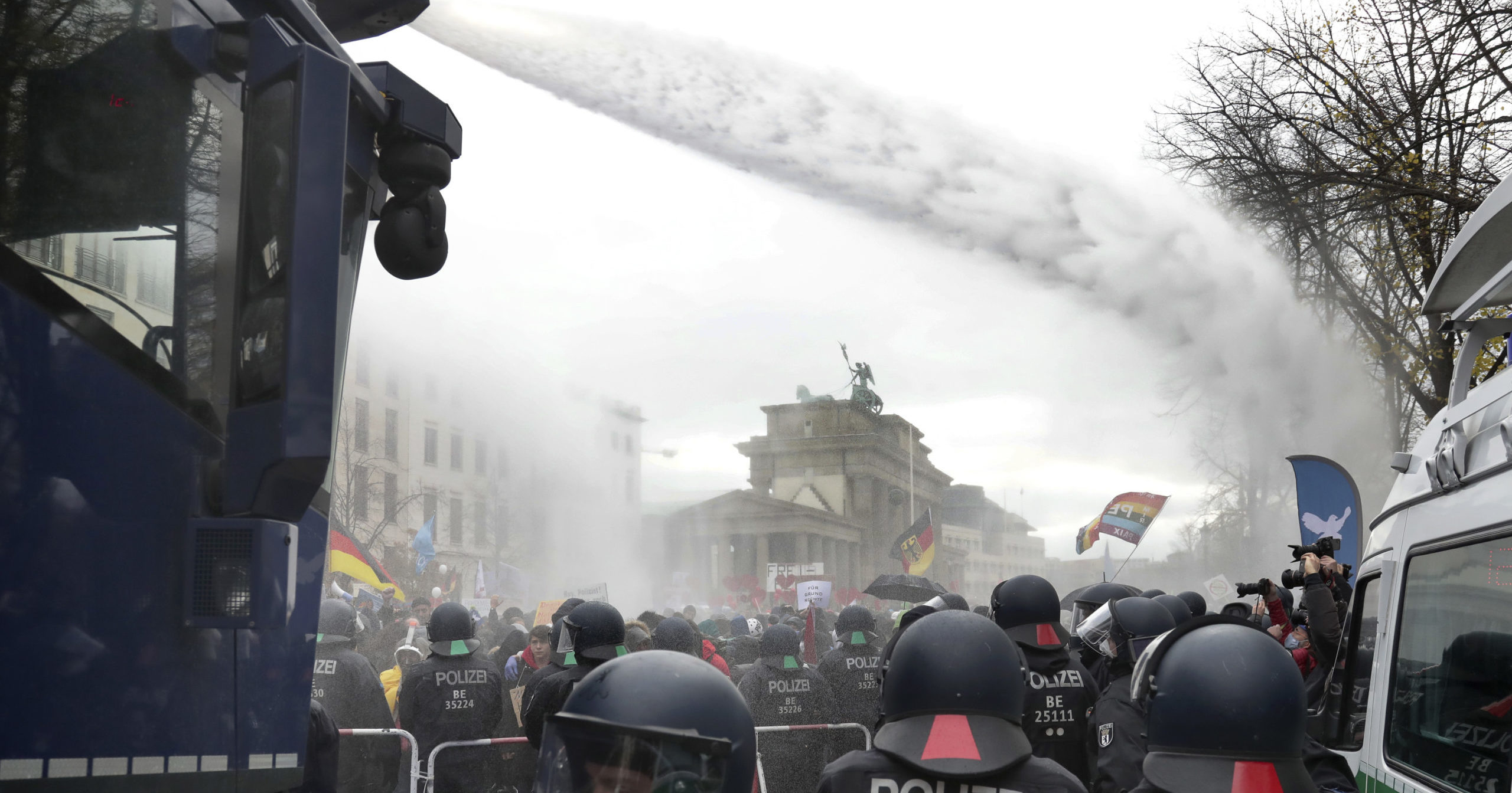 Police use water cannons to move people protesting coronavirus restrictions Wednesday near the Brandenburg Gate in Berlin.