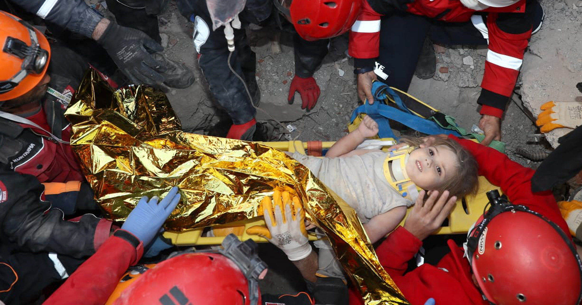 Rescue workers surround Ayda Gezgin in the coastal city of Izmir, Turkey, on Nov. 3, 2020, after pulling her out alive from the rubble of a collapsed apartment building four days after a strong earthquake hit Turkey and Greece.