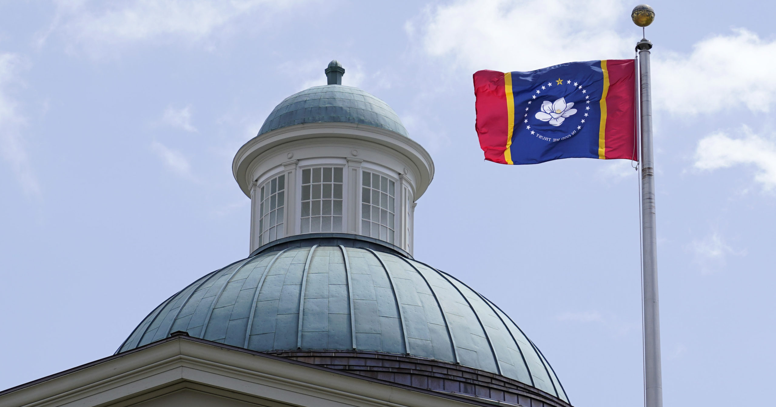 The magnolia flower-centered banner chosen Sept. 2 by the Mississippi State Flag Commission flies outside the Old State Capitol Museum in downtown Jackson.