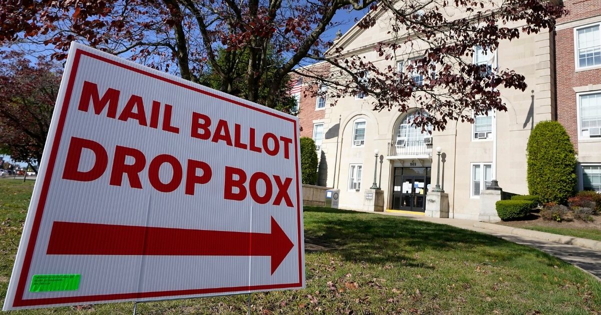 A sign points the way to a ballot drop box in front of Cranston City Hall on Oct. 15 in Cranston, Rhode Island.