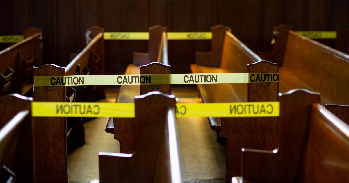 The above stock photo shows caution tape blocks off church pews in regulation with social distancing guidelines due to Coronavirus.