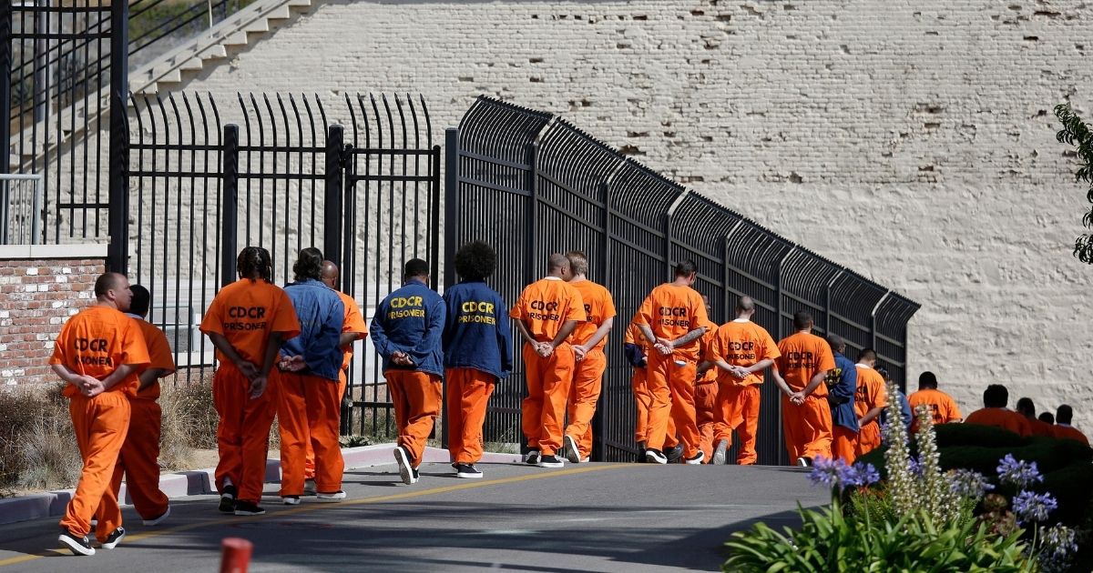 In this Aug. 16, 2016, photo, general population inmates walk in a line at San Quentin State Prison in San Quentin, California.