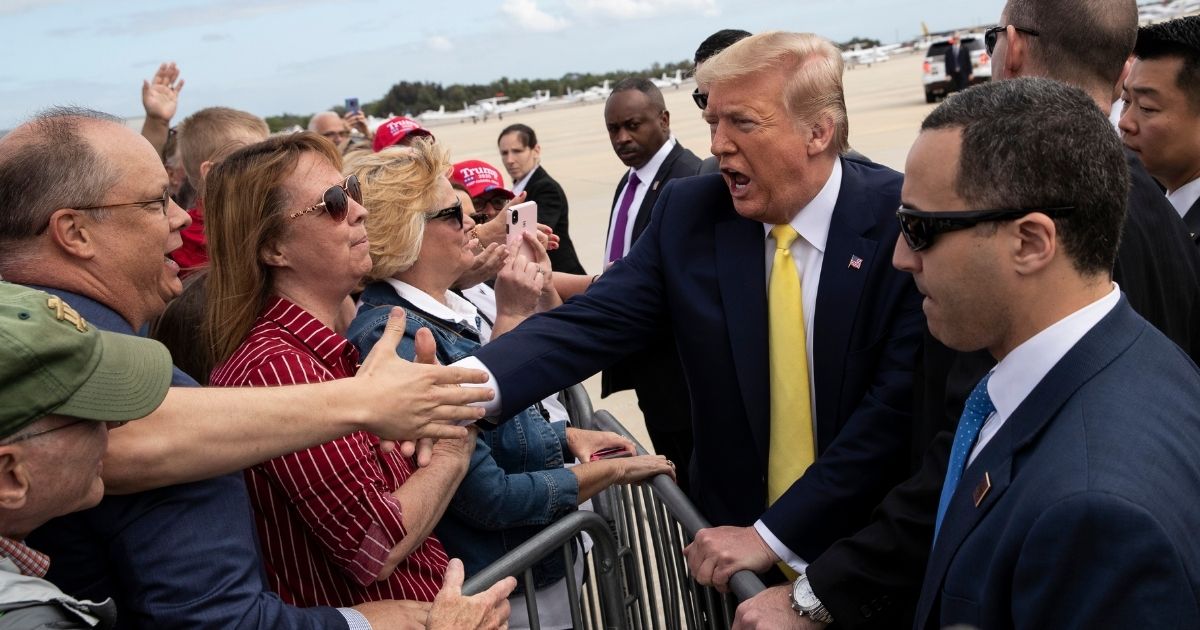 President Donald Trump shakes hands with supporters upon arrival at the Orlando Sanford International Airport on March 9, 2020 in Orlando, Florida.