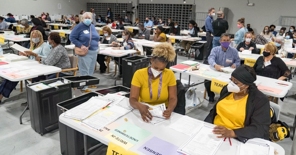 Gwinnett County election workers handle ballots as part of the recount for the 2020 presidential election at the Beauty P. Baldwin Voter Registrations and Elections Building in Lawrenceville, Georgia, on Monday.