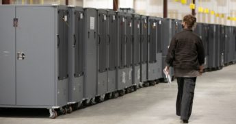 A Georgia Republican Party poll watcher looks over voting machine transporters being stored at the Fulton County Election Preparation Center in Atlanta on Nov. 4.