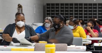 Gwinnett County election workers handle ballots Monday as part of the recount for the 2020 presidential election at the Beauty P. Baldwin Voter Registrations and Elections Building in Lawrenceville, Georgia.