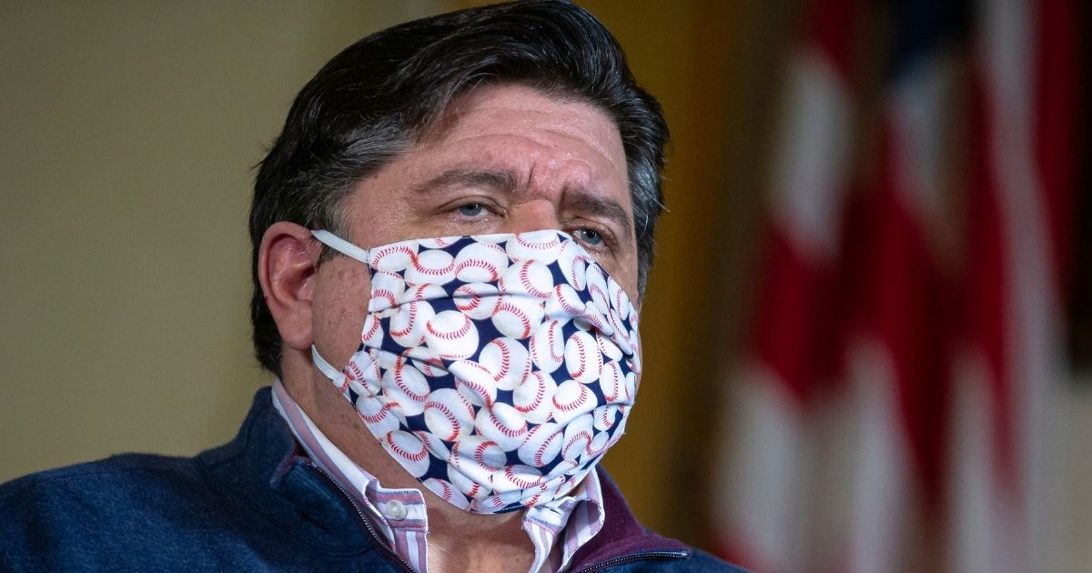Illinois Gov. J.B. Pritzker wears a face mask made of a fabric with baseballs printed on it during his daily news briefing on the COVID-19 pandemic held in his office at the Illinois State Capitol on May 21, 2020, in Springfield, Illinois.