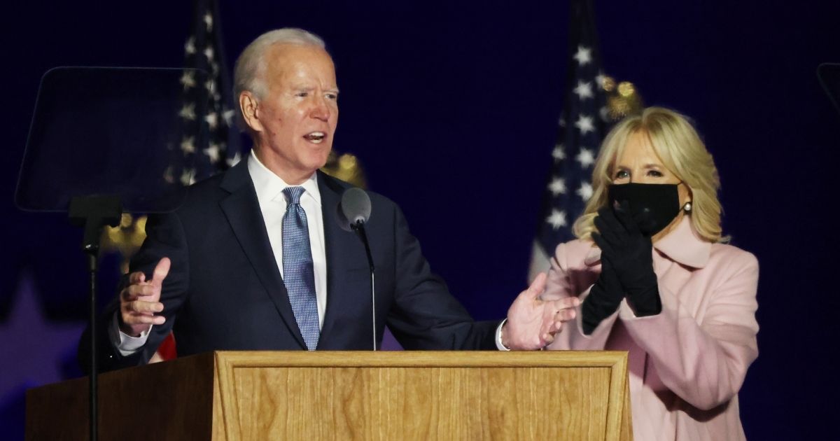 Democratic presidential nominee Joe Biden speaks at a drive-in election night event as Dr. Jill Biden looks on at the Chase Center in the early morning hours of Wednesday in Wilmington, Delaware.