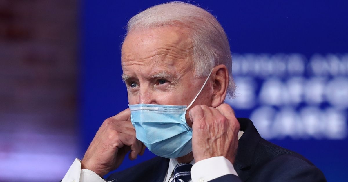 Presumptive president-elect Joe Biden removes his mask before addressing the media about the Trump administration’s lawsuit to overturn the Affordable Care Act in Wilmington, Delaware, on Tuesday.