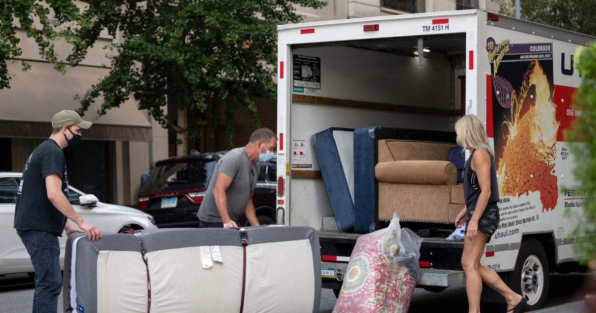 People wearing masks load furniture into a U-haul moving truck as the city continues Phase 4 of re-opening following restrictions imposed to slow the spread of coronavirus on Sept. 12 in New York City.