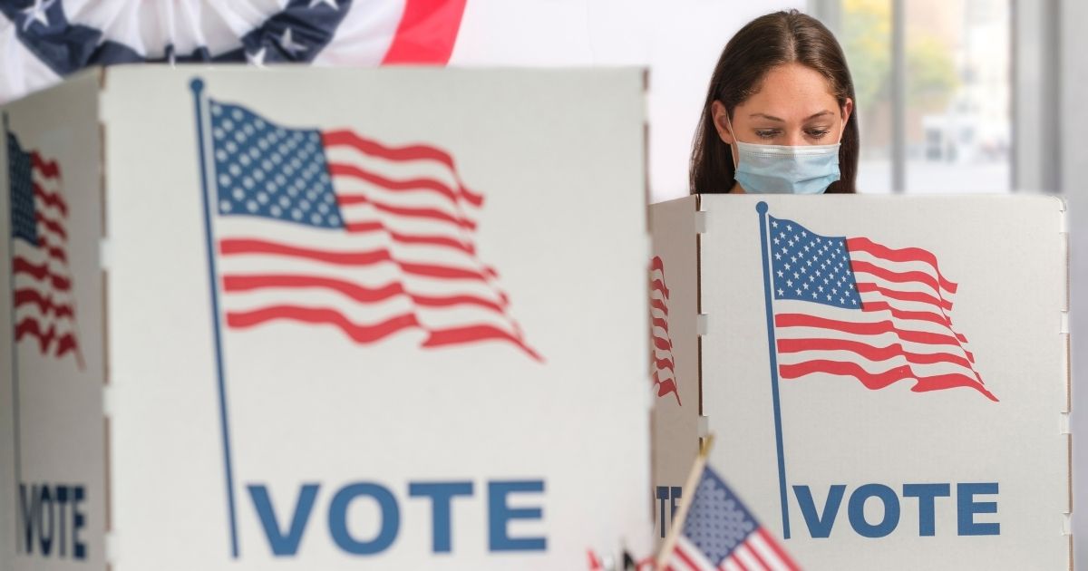 A stock image shows a woman voting.