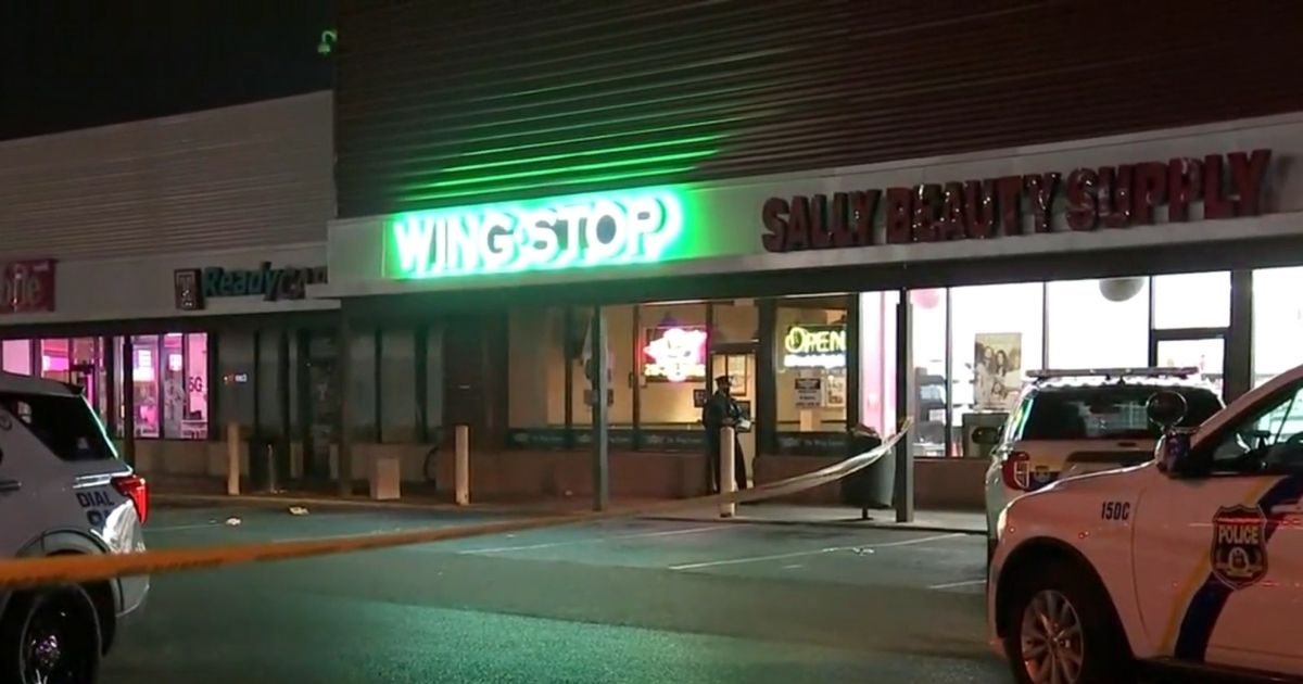 Police officers are at the scene of a shooting at a Wingstop restaurant in Philadelphia.