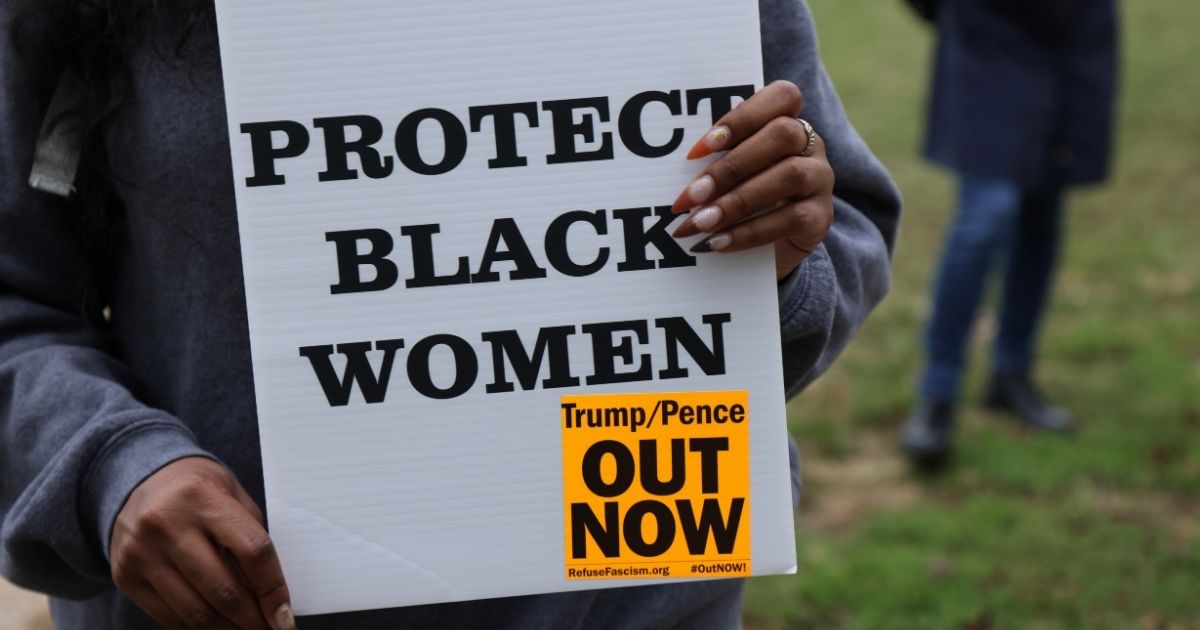 A woman holds a "Protect Black Women" sign at a rally on Oct. 16, 2020, in Washington, D.C.