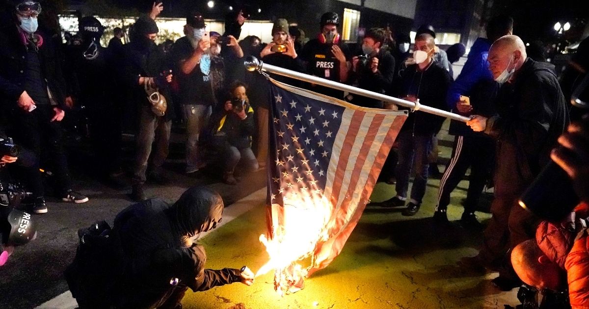 A protester lights an American flag on fire during a demonstration Wednesday in Portland, Oregon.
