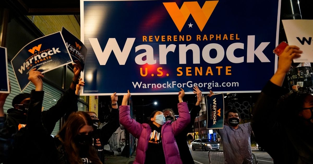 Supporters cheer Raphael Warnock, a Democratic candidate for the U.S. Senate, before a rally Nov. 3, 2020, in Atlanta.