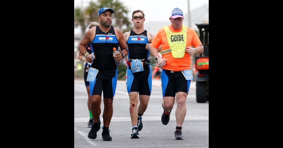 Chris Nikic, center, is the first person with Down syndrome to complete an IRONMAN Triathlon.