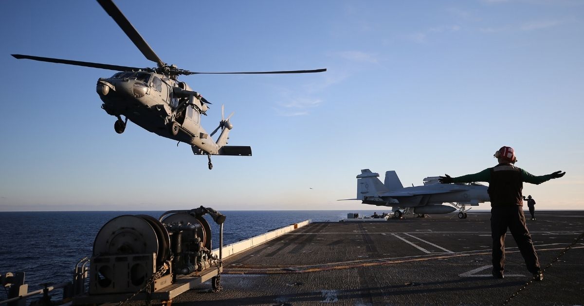 A U.S. Navy helicopter descends to land on the flight deck of the USS Nimitz (CVN 68) aircraft carrier while at sea on Jan. 18 off the coast of Baja California, Mexico.