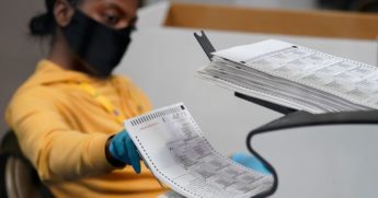 A county election worker scans mail-in ballots at a tabulating area at the Clark County Election Department on Thursday.