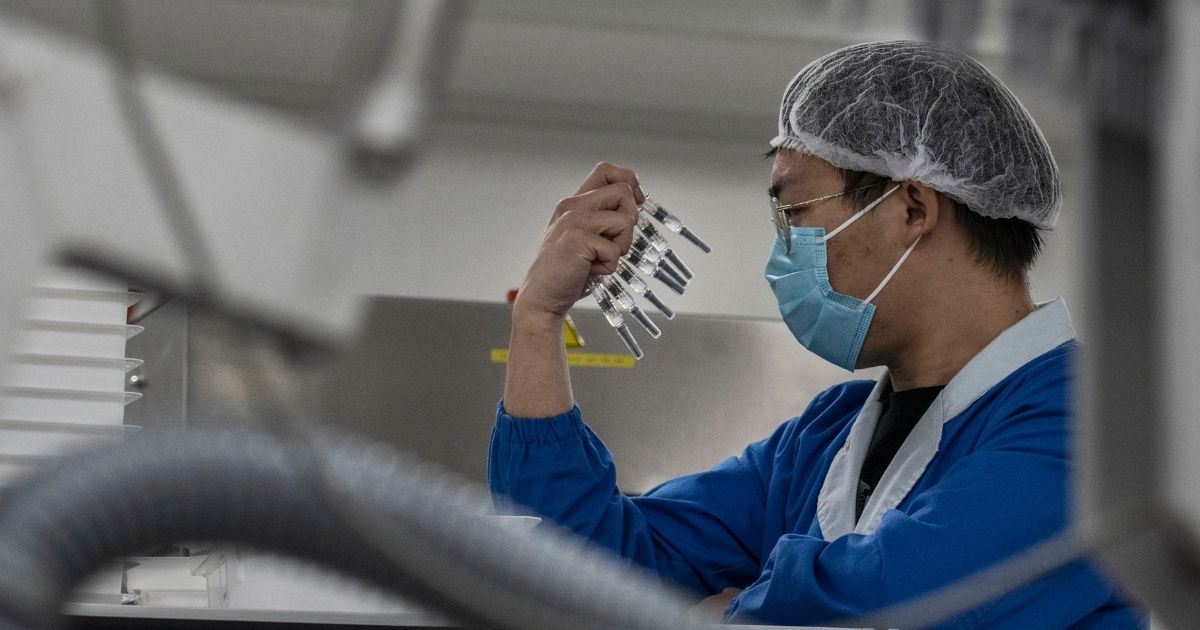A worker checks syringes of the potential vaccine CoronaVac on the production line at Sinovac Biotech on Sept. 24, 2020, in Beijing.