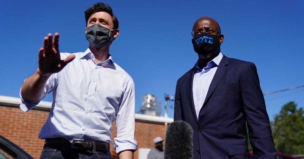 Democratic U.S. Senate candidates Jon Ossoff and Raphael Warnock campaign at an event in Lithonia, Georgia, on Oct. 3, 2020. The two hope to unseat incumbent Senators David Perdue and Kelly Loeffler.