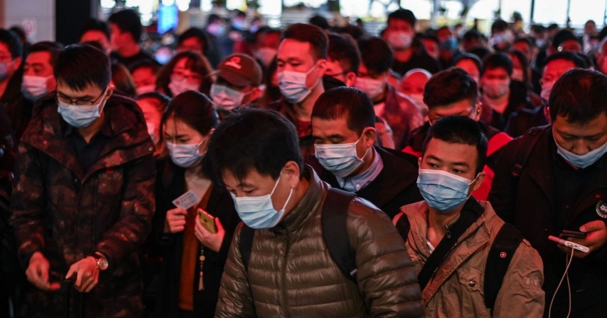 Passengers wearing face masks as a preventive measure against the coronavirus walk to their train at Wuhan railway station in China's central Hubei province on Wednesday.