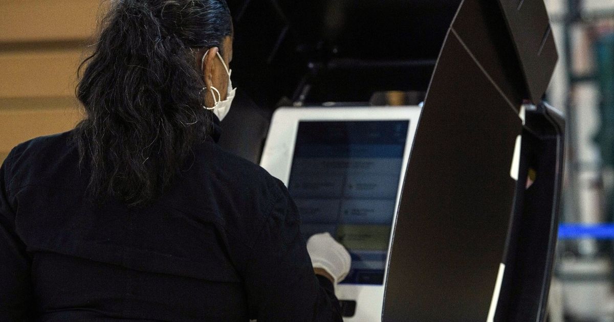 A woman uses a voting machine