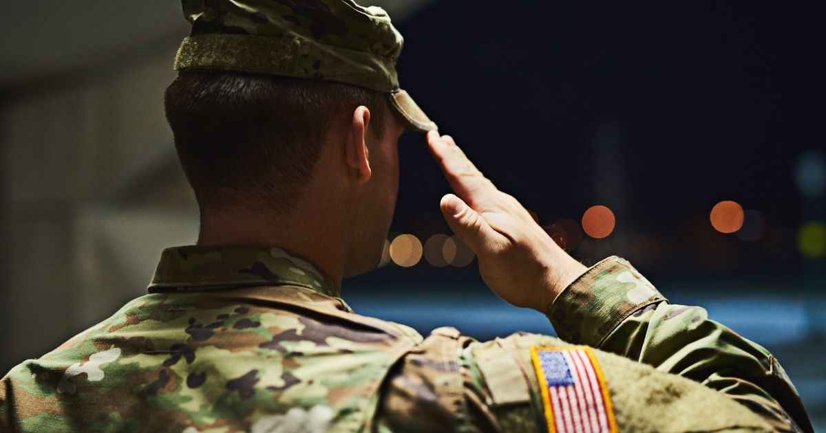 An Army soldier salutes in the above stock image.