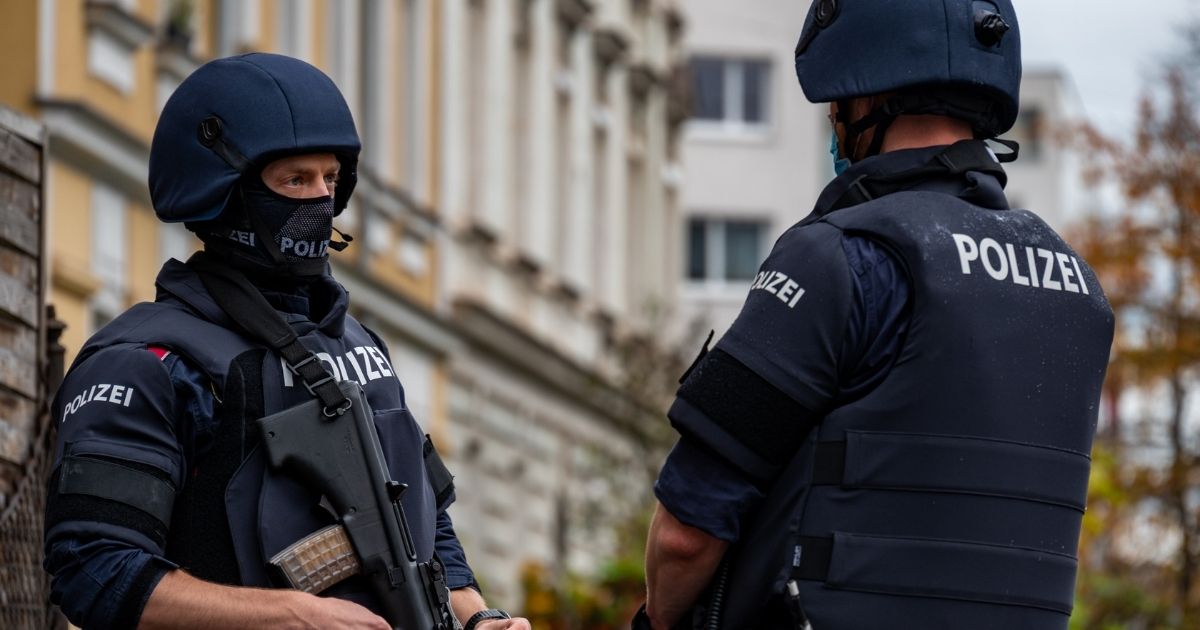 Policemen stand guard in front of a residential building in Linz, Austria, where a man was detained on Nov. 3, 2020, in connection with an Islamist shooting in Vienna the day before.