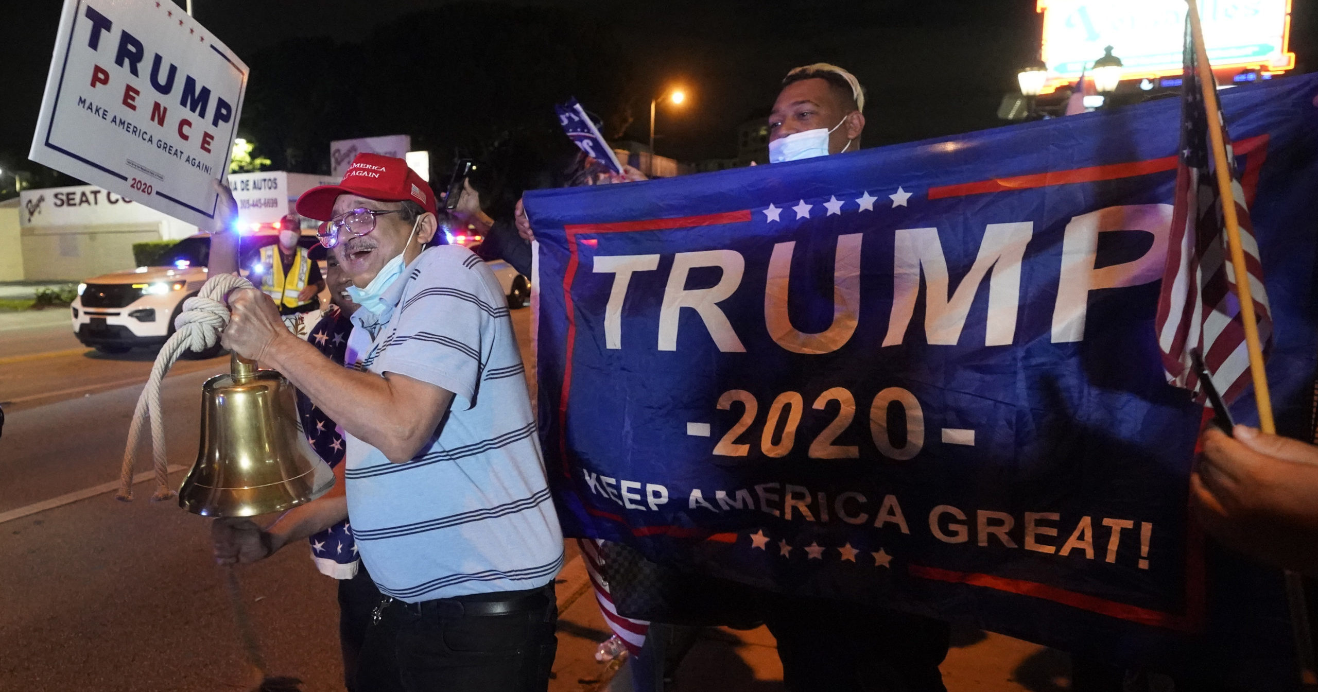 In this Nov. 3, 2020, photo, supporters of President Donald Trump chant and wave flags outside a Cuban restaurant during a celebration on election night in the Little Havana neighborhood of Miami.