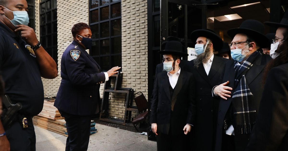 Members of the New York Police Department speak with Orthodox Jews outside a synagogue on Oct. 19, 2020, in the Williamsburg neighborhood of the Brooklyn borough of New York City.