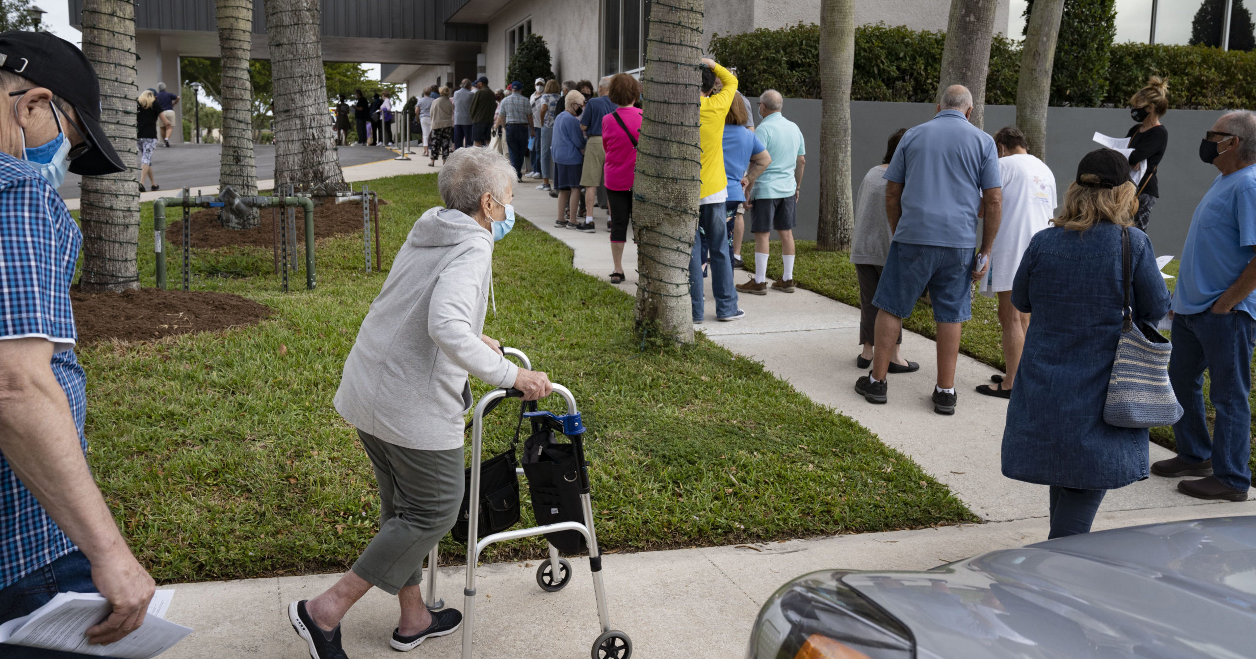 Seniors stand in line to make an appointment to receive the Moderna COVID-19 vaccine outside the King's Point clubhouse in Delray Beach, Florida, on Dec. 30, 2020.
