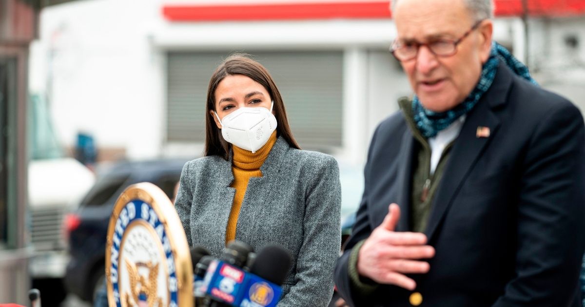 Senate Minority Leader Chuck Schumer speaks as Democratic Rep. Alexandria Ocasio-Cortez of New York listens during a news conference in the Corona neighborhood of Queens on April 14, 2020, in New York City.