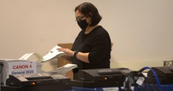 A poll worker scans ballots at the Maricopa County Recorder's Office in Phoenix where votes in the general election are being counted on Nov. 5, 2020.