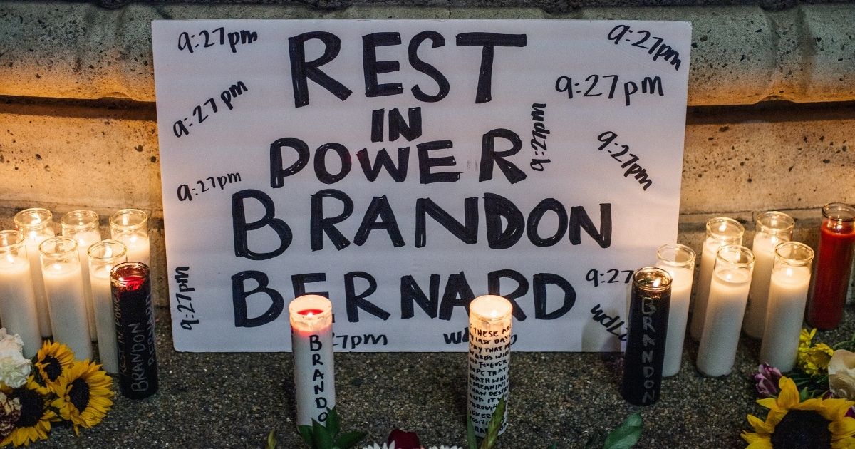 A sign is seen at a candlelight vigil for Brandon Bernard on Sunday in Los Angeles.