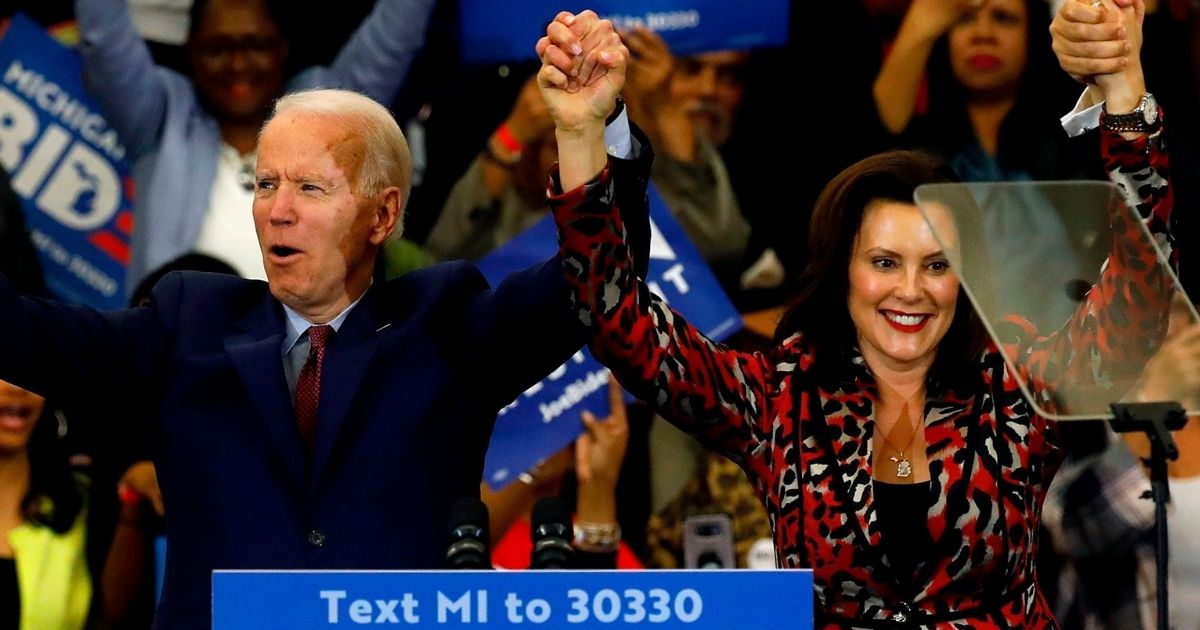 Democratic presidential candidate Joe Biden joins hands with Michigan Gov. Gretchen Whitmer during a campaign rally at Renaissance High School in Detroit on March 9.
