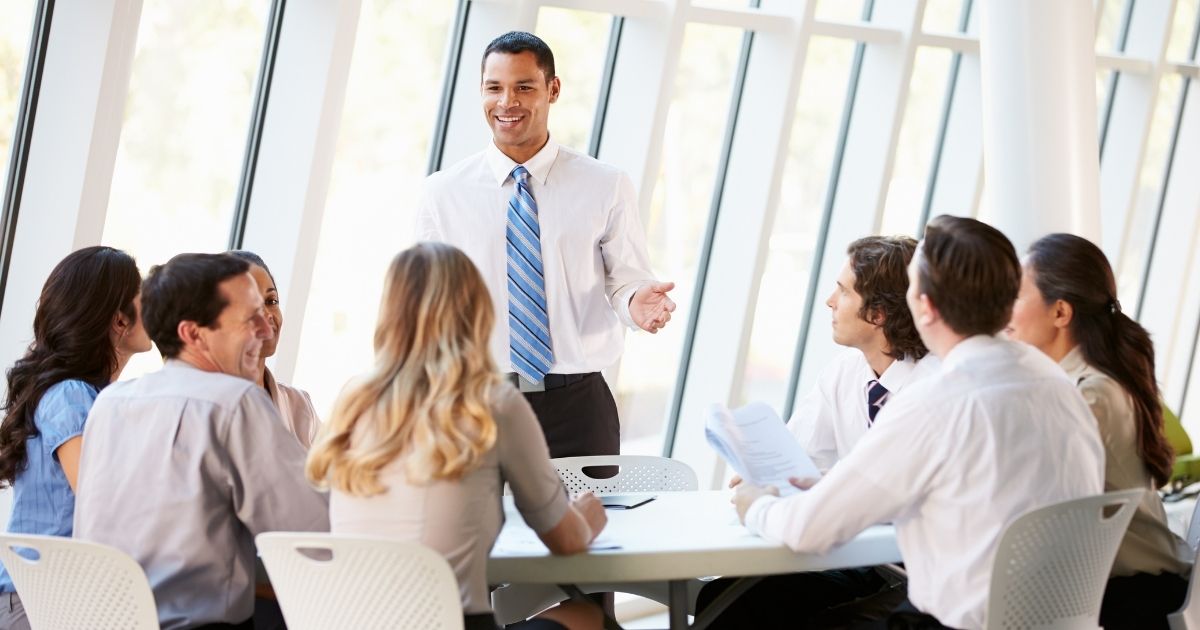 Employees participate in an office meeting in the stock image above.