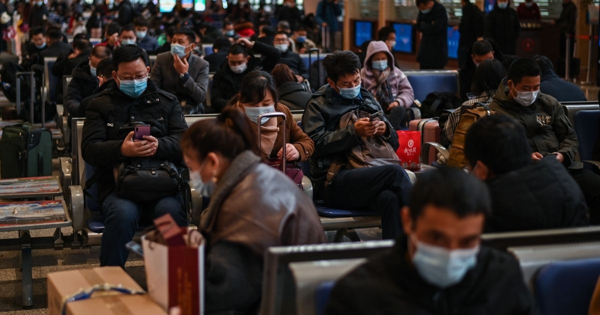 Passengers wearing face masks as a preventive measure against COVID-19 wait for their train in Wuhan, China, on Wednesday.