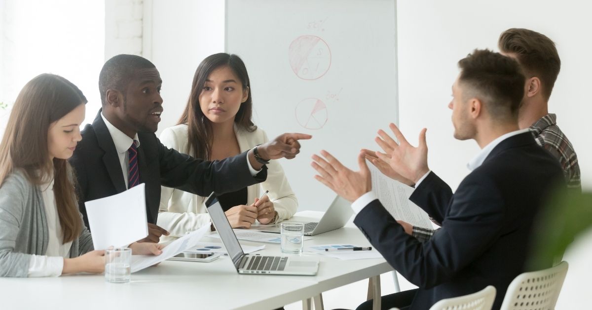 A group of people debate around a table in the stock image above.