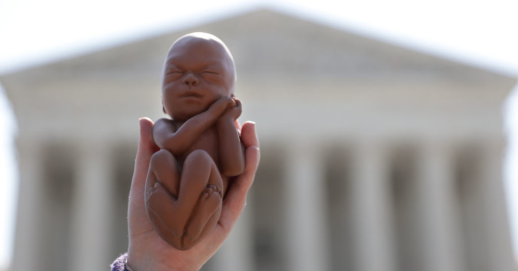 A pro-life activist holds up a model of a fetus during a protest in front of the U.S. Supreme Court June 22, 2020 in Washington, DC.