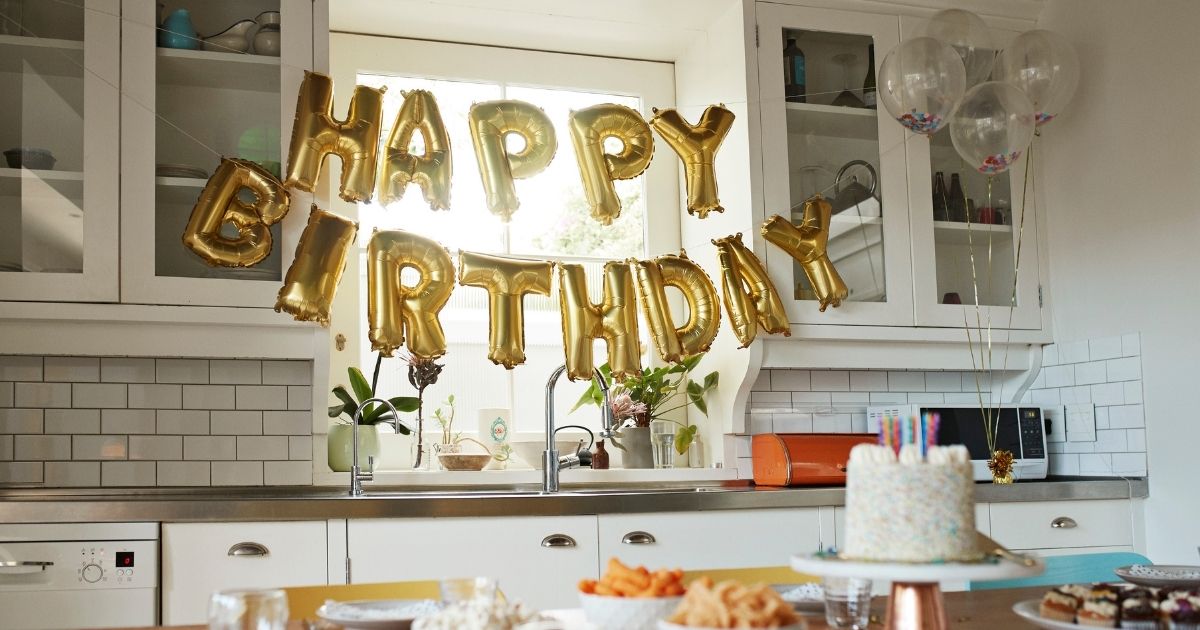 The above stock photo shows a happy birthday balloon display in a home.