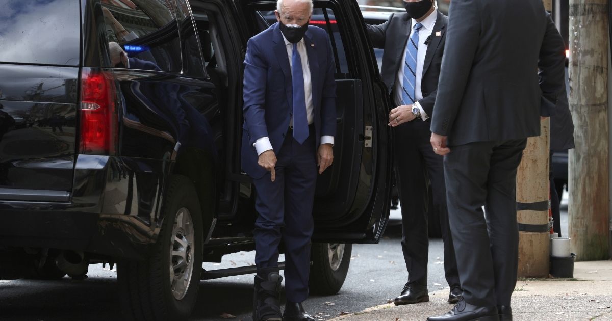 Joe Biden, wearing a walking boot due to hairline fractures after he strained his ankle playing with his dog Major, arrives at the Queen Theater to name his economic team on Tuesday in Wilmington, Delaware.