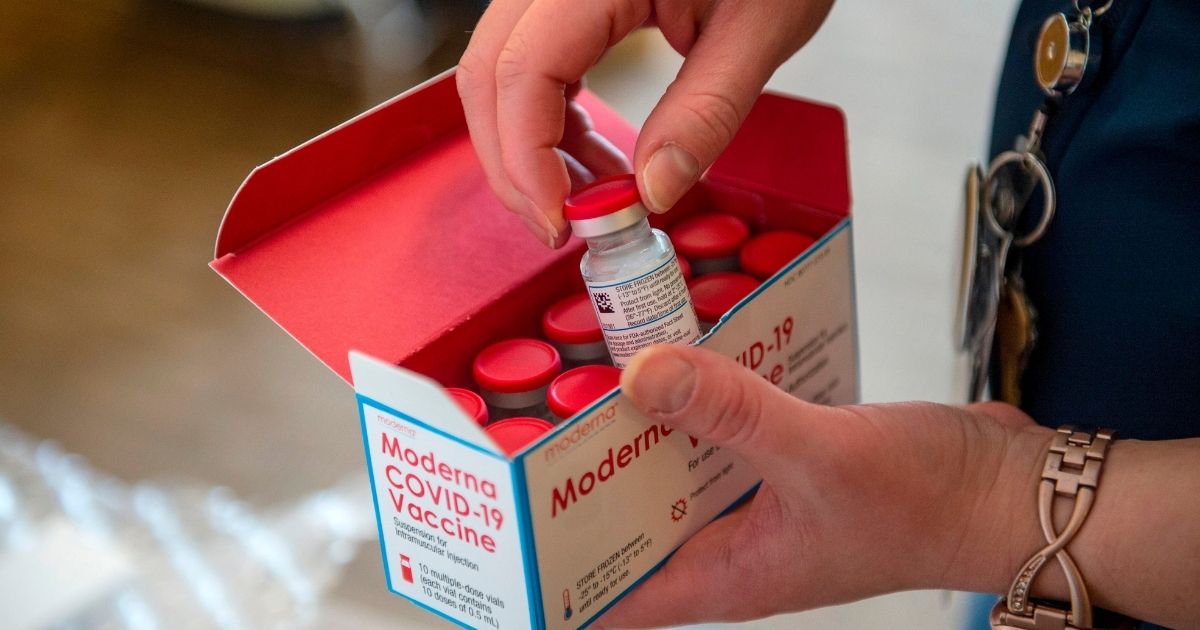 RN Courtney Senechal unpacks a special refrigerated box of Moderna Covid-19 vaccines as she prepared to ready more supply for use at the East Boston Neighborhood Health Center (EBNHC) in Boston on Thursday.