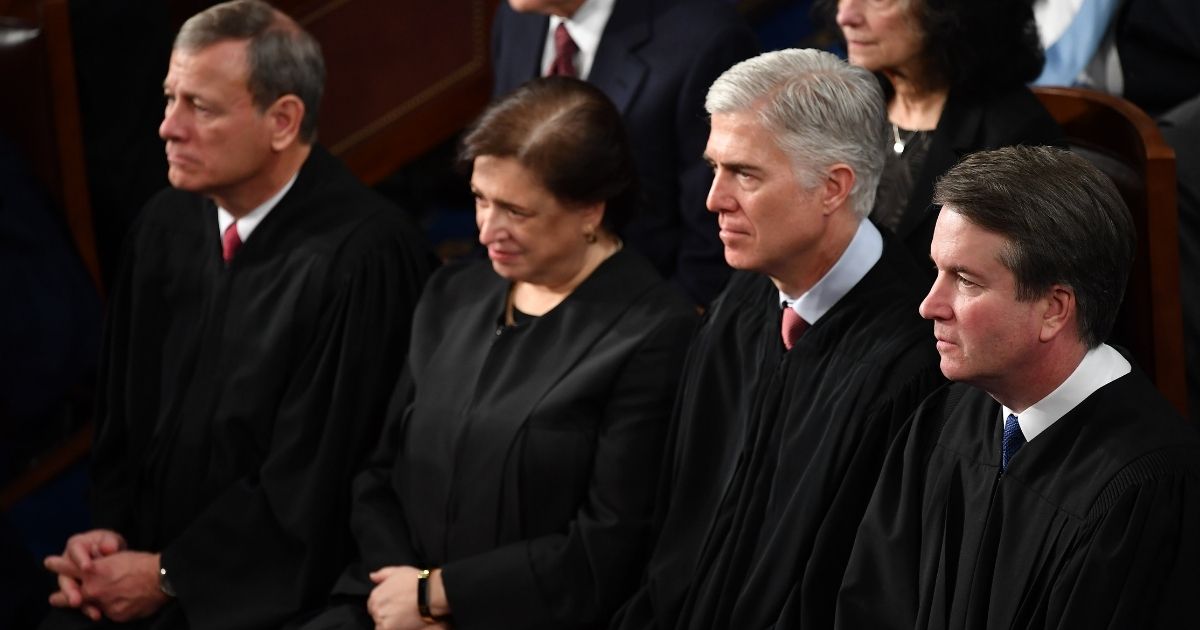 Supreme Court Justice Brett Kavanaugh (R), flanked by (from R-L) US Supreme Court Justice Neil Gorsuch, US Supreme Court Justice Elena Kagan, and US Supreme Court Chief Justice John Roberts, listens to US President Donald Trump's State of the Union address at the US Capitol in Washington, D.C., on Feb. 5, 2019.