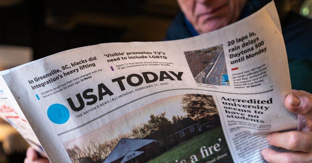 A man is pictured reading a USA Today newspaper in the stock image above.