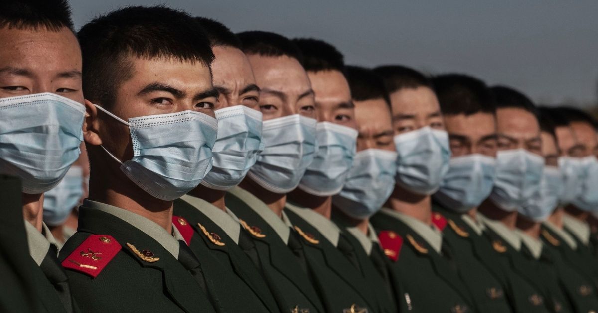 Chinese soldiers from the People's Liberation Army wear protective masks as they line-up after a ceremony marking the 70th anniversary of China's entry into the Korean War, on Oct. 23 in Tiananmen Square outside the Great Hall of the People in Beijing, China