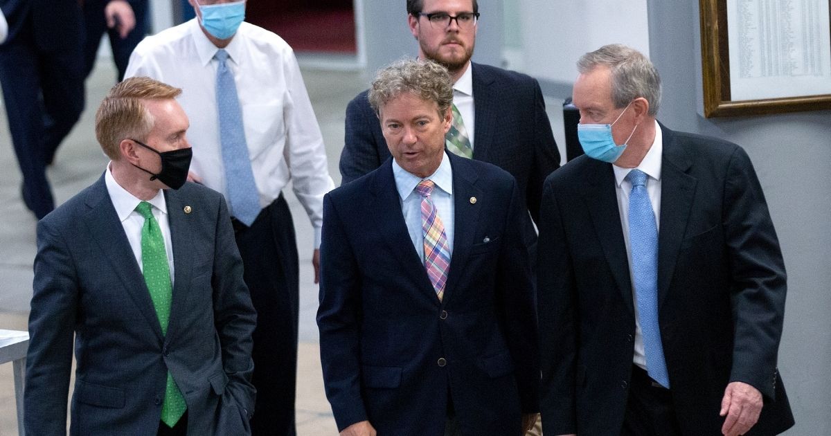 U.S. Sen. Rand Paul of Kentucky, maskless, is pictured with Sen. James Lankford of Oklahoma, left, and Sen. Mike Crapo of Idaho, right, walking through the Senate Subway in an August file photo.