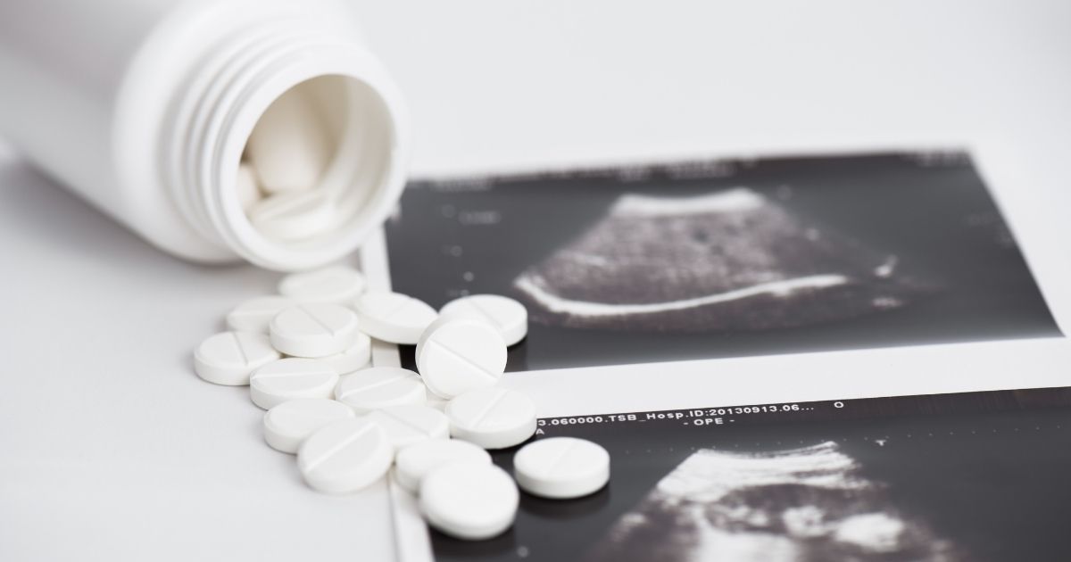 A picture of abortion pills next to an ultrasound in the above stock image.